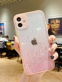 a woman holding up an iphone case with pink glitter on the front and back cover