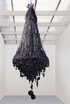 a black chandelier hanging from the ceiling in an empty room with white walls