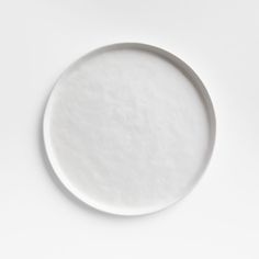 an empty white plate sitting on top of a table