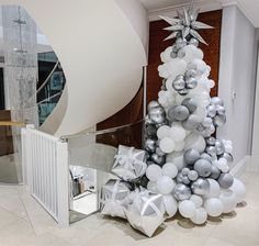 a silver and white christmas tree with balloons