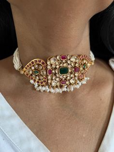 Simply a mark of royalty and elegance! You will definitely fall in love with the beautifully placed multicolored Kundan stones, One of our favorite picks for the wedding season. Do notice the beautiful pink beads in the pearl strings. Material: Copper Brass and silver mix, with gold plating Premium quality Choker Necklace Dimensions: Weight: 45 grams. Closure Type: Premium Adjustable Dori Earring Dimensions (Per Pair): Weight: 12 grams Length: 4.5 cm Width: 2 cm Closure Type: Push Back Closure with Extra Support Clip at the Back. Elegant Pink Multi-stone Necklace, Elegant Multi-stone Bridal Necklace For Festive Occasion, Elegant Multi-stone Bridal Necklace For Festivities, Elegant Multicolor Multi-stone Bridal Necklace, Elegant Festive Multi-stone Bridal Necklace, Elegant Multicolor Jeweled Bridal Necklace, Fusion Style Pearl Drop Jewelry For Celebration, Pearl Gemstone Jewelry For Party, Elegant Multi-stone Pearl Necklace For Gift