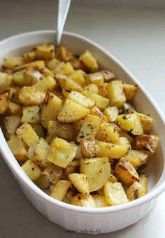 a white bowl filled with potatoes on top of a table