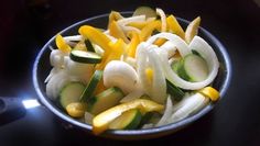 a bowl filled with sliced up vegetables on top of a table