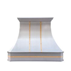 a large stainless steel range hood with gold trimmings on the front and sides