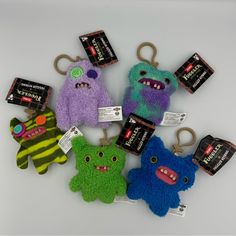 five different colored stuffed animals with tags on them