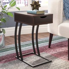 the end table has a book on it and is next to a chair with a pillow