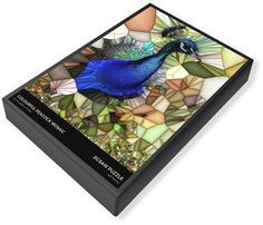 a blue bird sitting on top of a glass tile covered box with flowers and leaves in the background