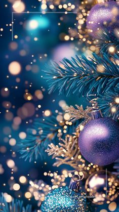 a blue christmas tree with ornaments and snow flakes on it's branches in the foreground