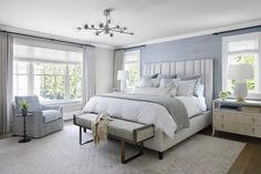 a bedroom with blue walls and white furniture