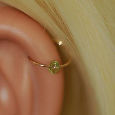 a close up view of a ear with a ring on it