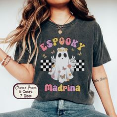 Retro Ghosts with a Twist! Elevate your style with this t-shirt featuring a vintage-inspired ghost and the Spanglish quote, 'Espooky Madrina.' It's a playful nod to the supernatural, perfect for those who embrace a blend of nostalgia and spooky sass. UNISEX Comfort Colors C1717 T-SHIRTS The Models in the pictures are wearing 1 or 2 sizes up, please order 1 or 2 sizes up for an oversized look. About Comfort Colors® C1717 ⭐️ 100% ring-spun cotton ⭐️ Preshrunk, Soft-washed, Garment-dyed Fabric ⭐️ H Vintage Halloween Fan Merchandise T-shirt, Retro Halloween T-shirt With Character Print, Black Vintage T-shirt For Fall, Vintage Halloween T-shirt With Letter Print, Spooky Graphic Print T-shirt For Fans, Vintage Halloween Tops With Character Print, Vintage Halloween Character Print Top, Vintage Halloween T-shirt With Character Print, Retro Halloween T-shirt With Crew Neck