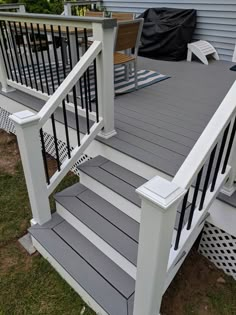 an outdoor deck with white railings and gray steps