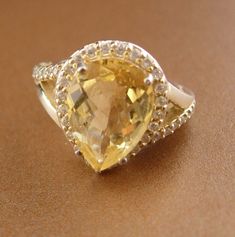 This is a beautiful multi faceted pear shaped large citrine gemstone with many faux diamonds bordering the main center piece. A great engagement/ cocktail ring. Crafted in sterling silver, size 5 3/4. Called The Merchant's Stone for its properties of increase in the cashbox, sparkling yellow Citrine not only assists in acquiring wealth, but helps in maintaining it. Carrying a Citrine attracts love and happiness, and guards against those who would break your heart. 11-3 2014 8-1-20 oct1 2020 Wedding Jewelry With Yellow Sapphire And Gemstone Accents, Elegant Pear-shaped Topaz Jewelry, Pear-shaped Gemstone Wedding Jewelry, Pear-shaped Gemstone Accents Jewelry For Anniversary, Pear-shaped Gemstone Accented Jewelry For Anniversary, Pear-shaped Gemstone Jewelry For Anniversary, Pear-shaped Gemstone Anniversary Jewelry, Pear-shaped Jewelry With Gemstone Accents, Yellow Gemstone Accented Wedding Jewelry