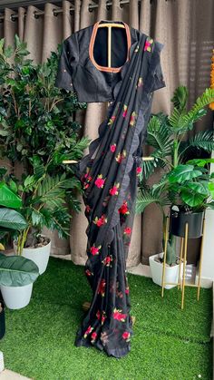 Product Descriptions : Black soft organza saree with scallop border and floral embroidery works all over saree is paired up with black silk high neck collar blouse having highlighted handworks for neck & sleeves .