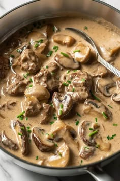 a pan filled with meat and mushrooms covered in gravy