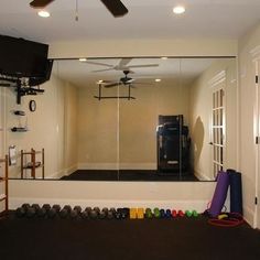 there is a mirror in the hallway with shoes on the floor and a television mounted to the wall