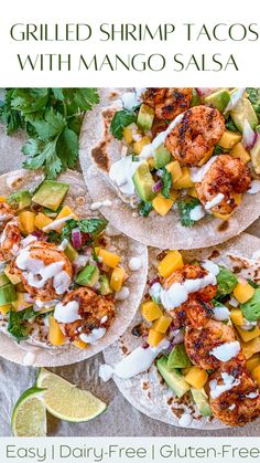 three grilled shrimp tacos with mango salsa on tortillas, garnished with cilantro and lime