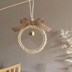 a baby crib with a bell hanging from it's side next to flowers