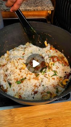 someone is cooking rice in a skillet on the stove with a spatula to stir it