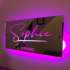 a purple neon sign that says sophiie studio on the side of a wall