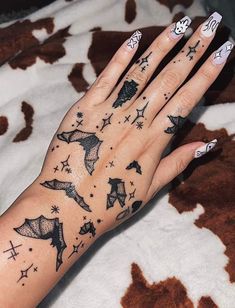 a woman's hand with black and white tattoos on it