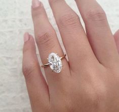 a woman's hand with a ring on it and a diamond in the middle