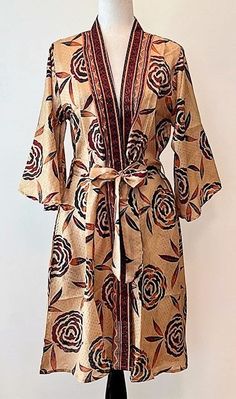 Classic Short Silk Kimono Dress is dramatic. Elegant, classic print in warm, fall colors. Handmade from high caliber silk. Self wrap framed with a wide front band placket. This Kimono has a beautiful finish. Tasteful and elegant, simple lines with an extra wide self tying belt. This wrap has everything; depth, interest, and designer appeal. Luxurious fabric, soft, opaque. The perfect duster jacket for cocktail parties, resort, beach or poolside cover-up. This silk Kimono dress is one of our most versatile styles. Produced in limited quantities and hand-stitched by tailors in an artisan studio. Designed as a duster kimono with multiple style options. Wear open and flowing over a pantsuit, slip dress (looks incredible), belted as a cocktail dress. Material is opaque, pliable and holds it's s Elegant Wrap Kimono With Floral Print, Elegant Multicolor Printed Kimono, Elegant Floral Print V-neck Kimono, Elegant Floral Print Wrap Robe, Fall Silk Kimono With Open Front, Fall Silk Open Front Kimono, Elegant Fall Kimono With Floral Print, Elegant Floral Print Fall Kimono, Elegant Fall Floral Print Kimono