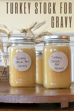 three jars with labels on them sitting on a table next to a sign that says turkey stock for gravy