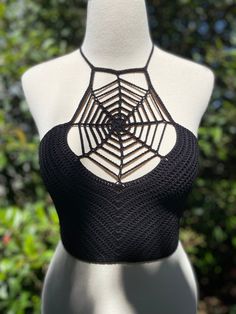 a mannequin wearing a black top with a spider web design on the back