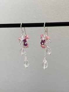 This pair of elegant shimmering sterling silver (925) drop earrings have been intricately crafted with beads hand wrapped onto silver and mounted like a cascade on a small silver chain. The stones are as follows: 2 faceted drops of rose quartz (size approx. 5 x 9 mm), 3 buttons each made of rhodochrosite (size 3 x 6 mm), 3 faceted beads made of rock crystal (diameter approx. 4 mm), 2 dice each of dark red, luminous ruby and 1 faceted button made of rhodochrosite (size approx. 3 x 4 mm). The earrings have a length of 5.5 cm. The ear hooks are 1.5 cm long, the pendants 4 cm. All silver parts used are sterling silver. The stones used as healing stones are also said to have a certain effect: Rose Quartz is the stone for the heart - it represents compassion, love, unconditional love, self-love Silver Crystal Earrings With Gemstones, Silver Dangle Earrings With Gemstone Beads, Sterling Silver Gemstone Beads Dangle Earrings, Sterling Silver Dangle Earrings With Gemstone Beads, Pink Briolette Earrings With Natural Stones, Pink Briolette Natural Stone Earrings, Elegant Wedding Earrings With Gemstone Beads, Silver Crystal Dangle Earrings With Natural Stones, Silver Teardrop Chandelier Earrings With Natural Stones