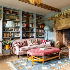 a living room filled with furniture and a fire place next to a book shelf full of books