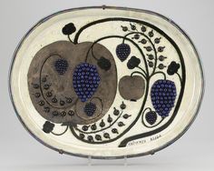 a white plate with blue and black designs on it's sides, in the shape of an apple