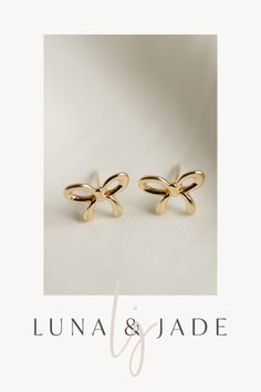 Experience the magic of Luna & Jade's Bow Studs – a stunning combination of elegance and fun. These versatile earrings make the perfect gift idea for any occasion, offering a touch of whimsy and charm to any outfit. Get ready to make an impression with these irresistible accessories. Shop Now! Gold Dainty Bow Earrings, Gold Dainty Earrings With Bow, Dainty Gold Earrings With Bow, Dainty Gold Bow Earrings, Gold Earrings With Bow Tie Detail For Gift, Gold Bow Tie Earrings For Gift, Cute Gold Bow Earrings, Cute Bow Earrings For Gifts, Small Gold Cute Earrings