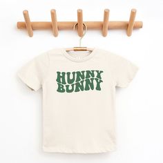 Looking for a cute tee for your kids? We have the perfect Hunny Bunny Wavy graphic tee addition to their closet! Also available in toddler tees. Playful Slogan T-shirt For Spring, Funny Cartoon Print T-shirt For Spring, Playful Cotton T-shirt With Letter Print, Family Matching Letter Print T-shirt For Spring, Playful Spring T-shirt With Text Print, Unisex Cute Slogan T-shirt, Cute Unisex Slogan T-shirt, Green Family Matching T-shirt With Graphic Print, Family Matching Green T-shirt With Graphic Print