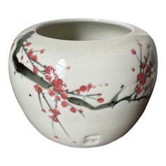 a white vase with red flowers painted on it