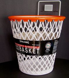 an orange and white basket sitting on top of a black table next to a basketball hoop