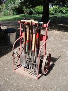 a red cart filled with gardening tools next to a tree