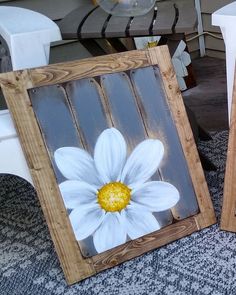 two wooden frames with white flowers painted on them sitting on the floor next to each other