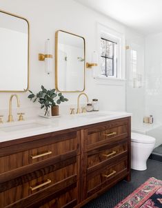 a bathroom with two sinks, a toilet and a bathtub next to each other