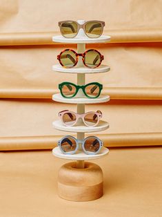 a stack of sunglasses sitting on top of a wooden stand