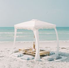 a white tent set up on the beach