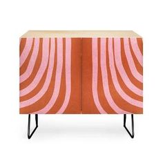 an orange and pink cabinet with black legs