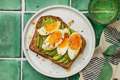 an egg and asparagus toast on a plate next to a glass of water