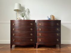 two wooden dressers sitting next to each other on top of a hard wood floor