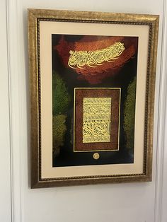 a painting hanging on the wall in a room with white walls and gold trimmings