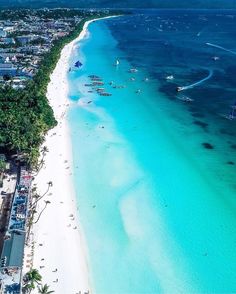 an aerial view of a beach with boats in the water