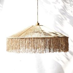 a light that is hanging from the ceiling with fringes on it's sides