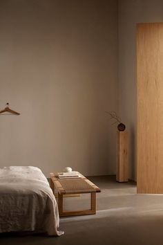 a bed sitting next to a wooden door in a bedroom