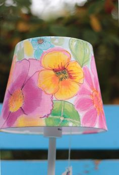 a lamp shade with flowers painted on it