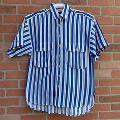 This is a super rad men's 80s shirt. White and blue striped short sleeve. 2 large pockets on the chest.  💯 % Cotton! Very breathable. Small discoloration spot/yellow (not stain treated yet) on right pocket (see pic). Not very noticeable, actually hard to photograph it 😂 This is unisex.  Gives me total summer vibes. Let's get on yacht 🛥 and sail away baby! Labeled a size small. Measurements as follows: Pit to pit laying flat 20" inches  Length is 27" in the front and 29" in the back  I ship pr Striped Short Sleeve Shirt With Pockets, Striped Cotton Short Sleeve Shirt, Striped Cotton Camp Shirt With Short Sleeves, Striped Collared Cotton Camp Shirt, Striped Cotton Shirt With Short Sleeves, Retro Cotton Camp Shirt With Pockets, Retro Short Sleeve Shirt With Pockets For Summer, Striped Collared Shirt With Pockets, Retro Vertical Stripes Short Sleeve Shirt